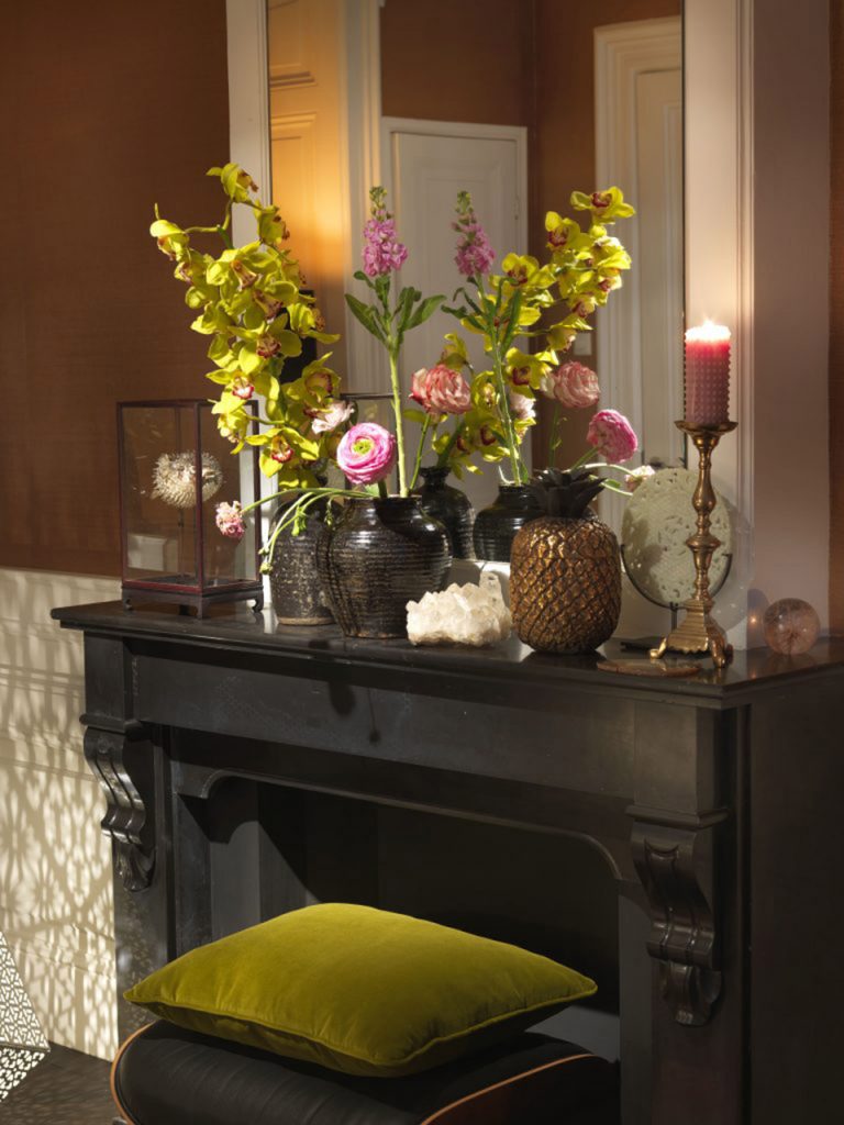 A mantelpiece with flowers and candles