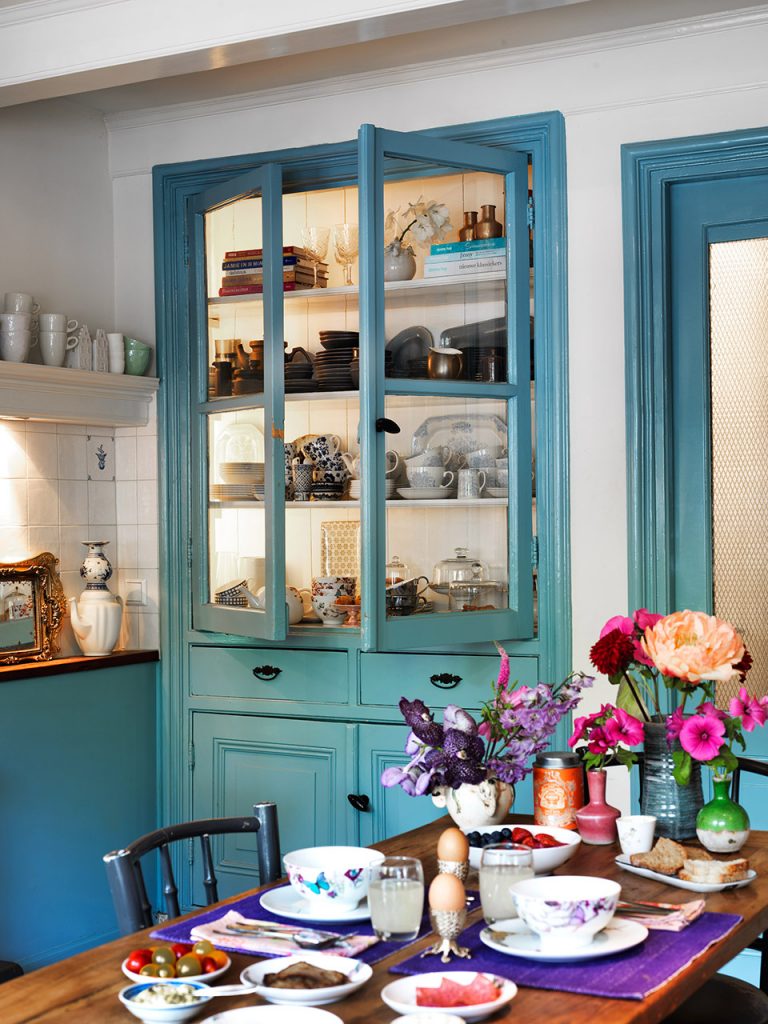 Breakfast table set beside a blue cabinet