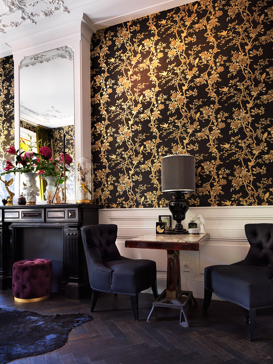 A moody lounge with velvet chairs and a round table