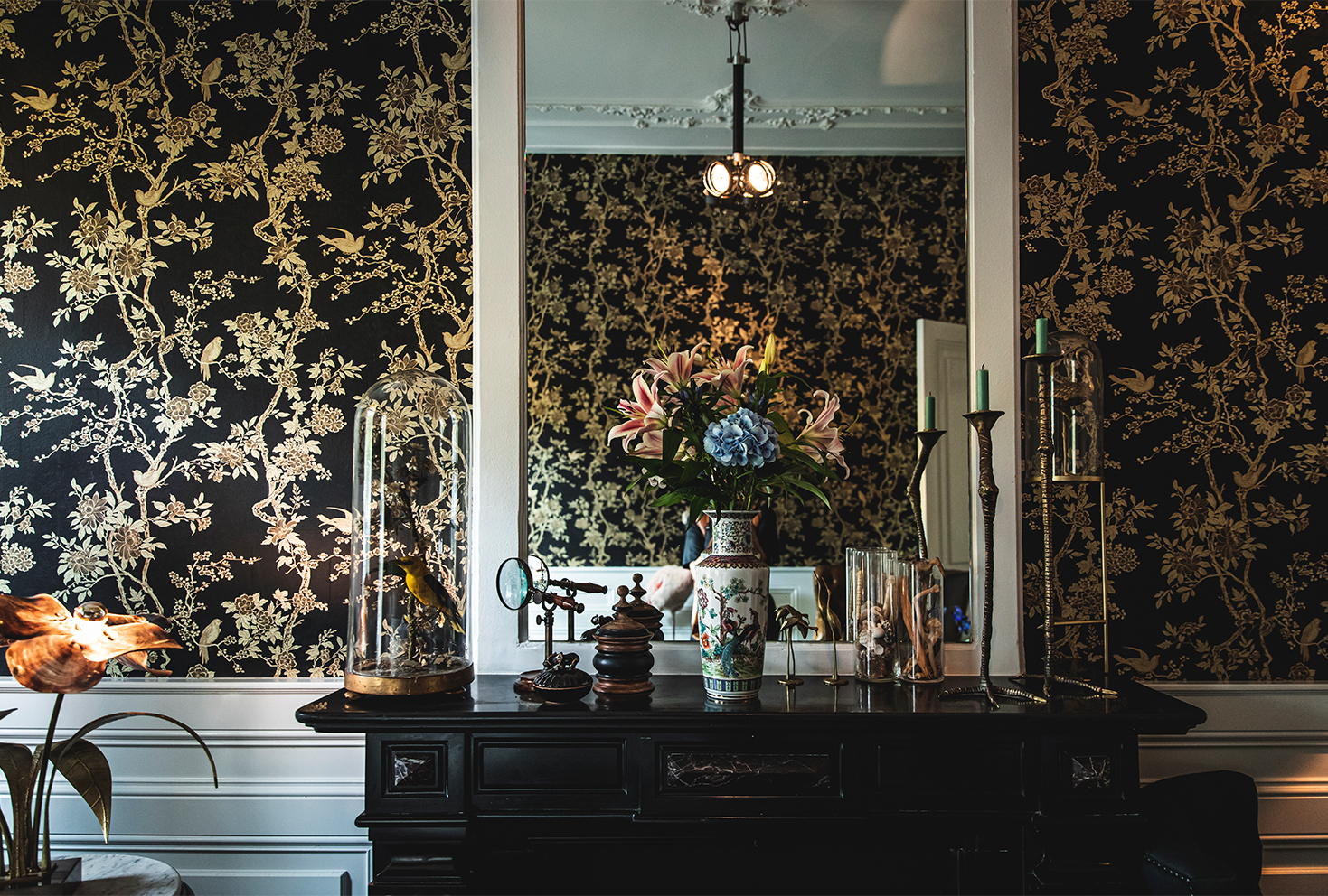 A dramatic vignette against dark floral wallpaper