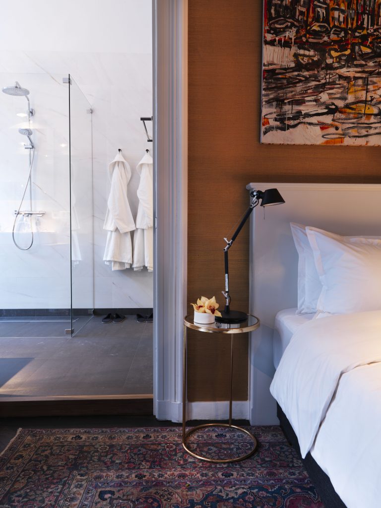 The Urban Suite bathroom with a walk-in shower beside the bed